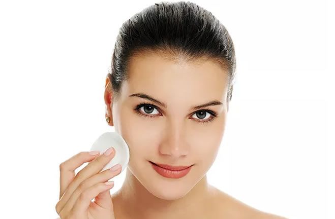 Close up portrait of woman holding a cotton pad
