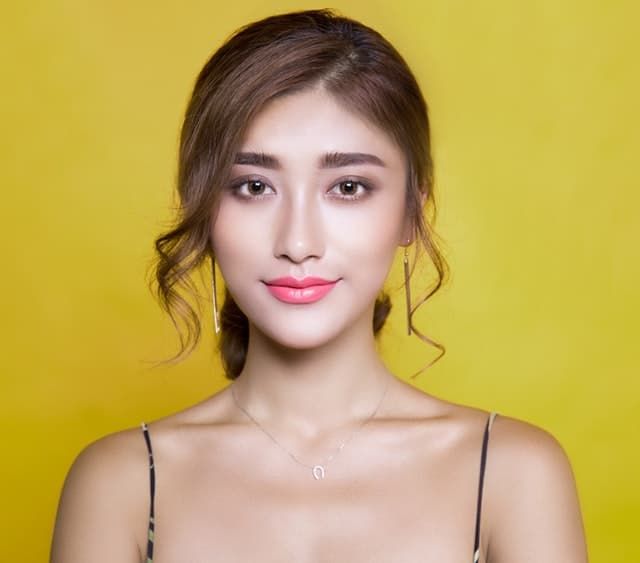 portrait of a woman smiling against yellow background