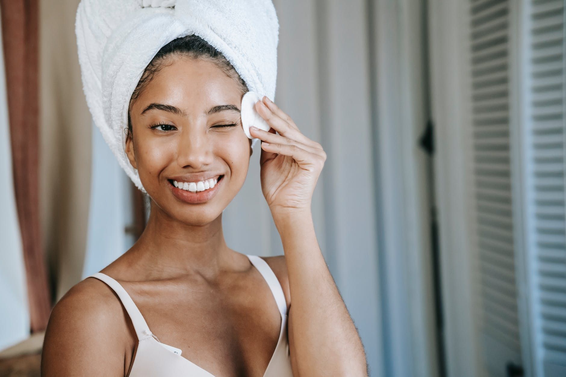 woman washing her face with her hair in a towel
